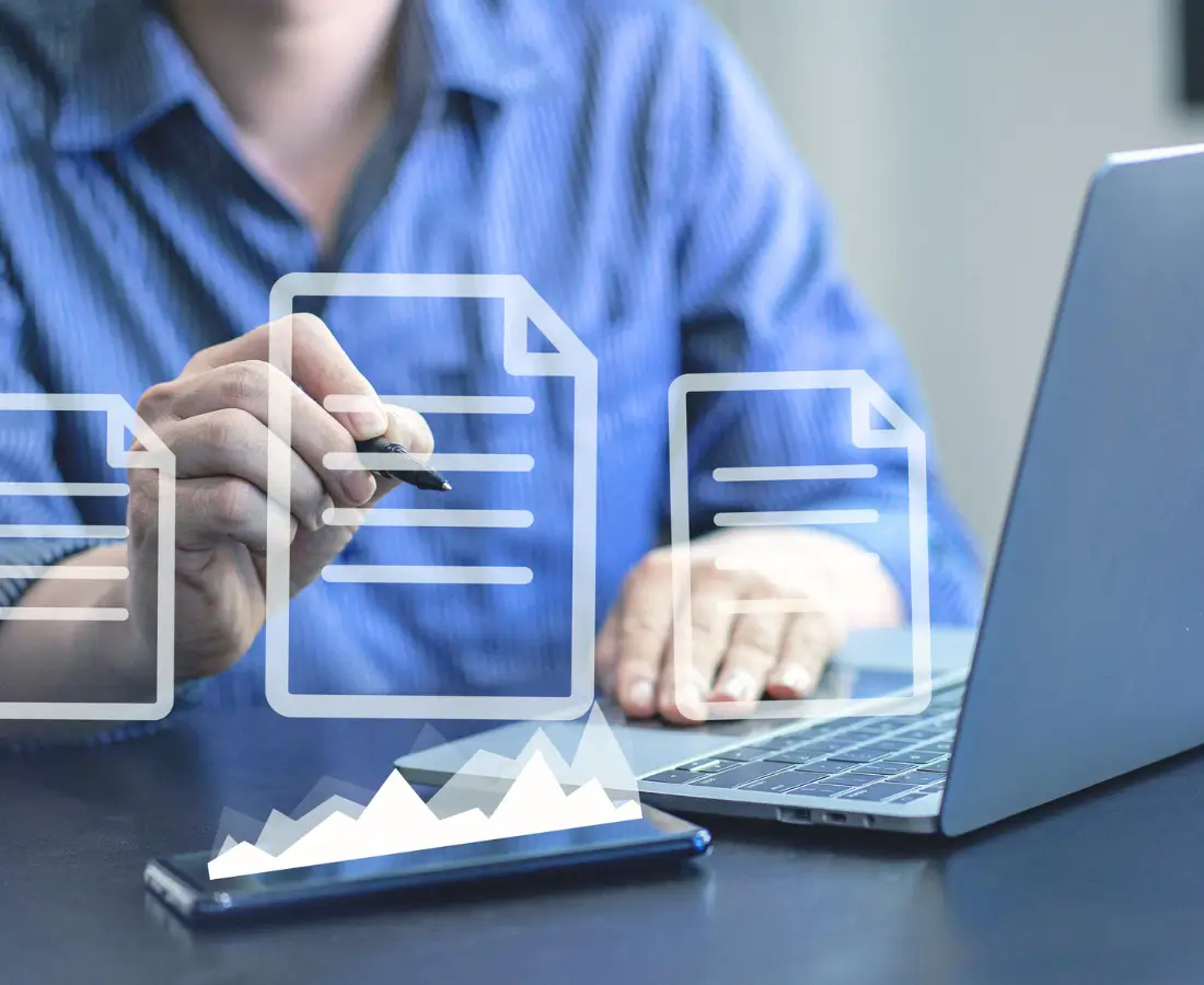 A man in blue button up, typing on his laptop