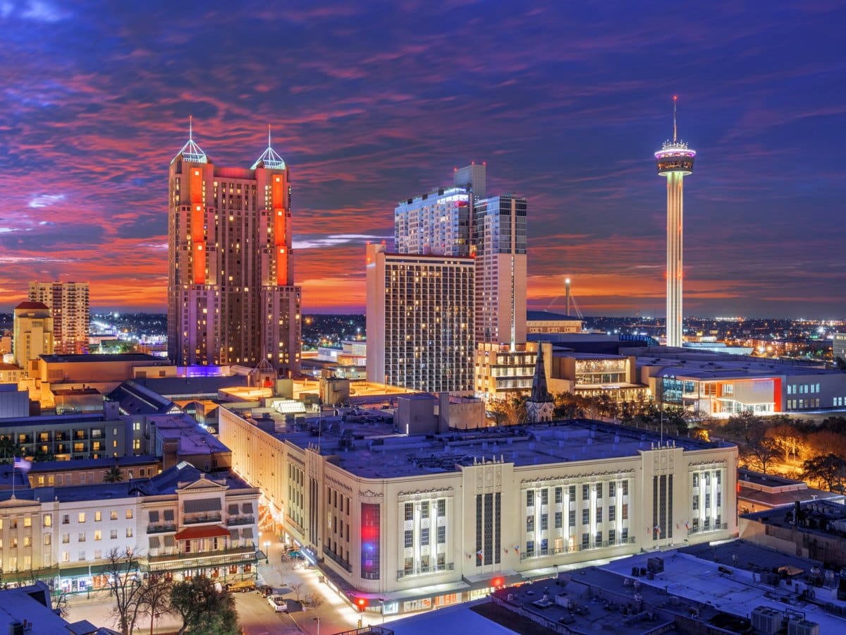 The San Antonio skyline at dusk, with the Tower of the Americas lit against a violet sky