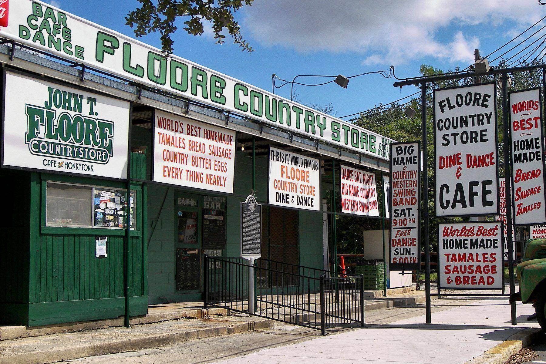 The green-and-white front of John T. Floore Country Store in Helotes, covered in hand-painted signs
