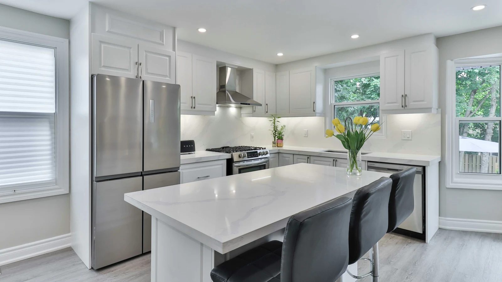 A bright modern kitchen with a long island and pendant lights
