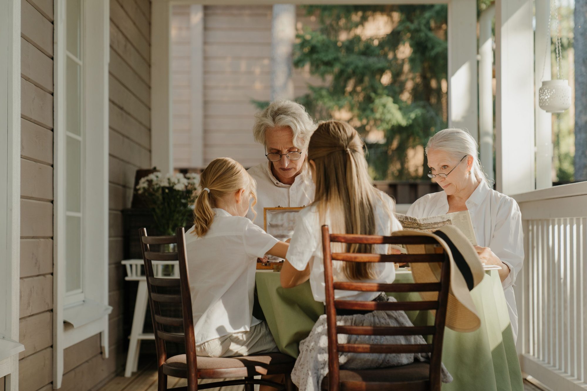 Grandparents sharing a meal with their grandchildren on a covered porch