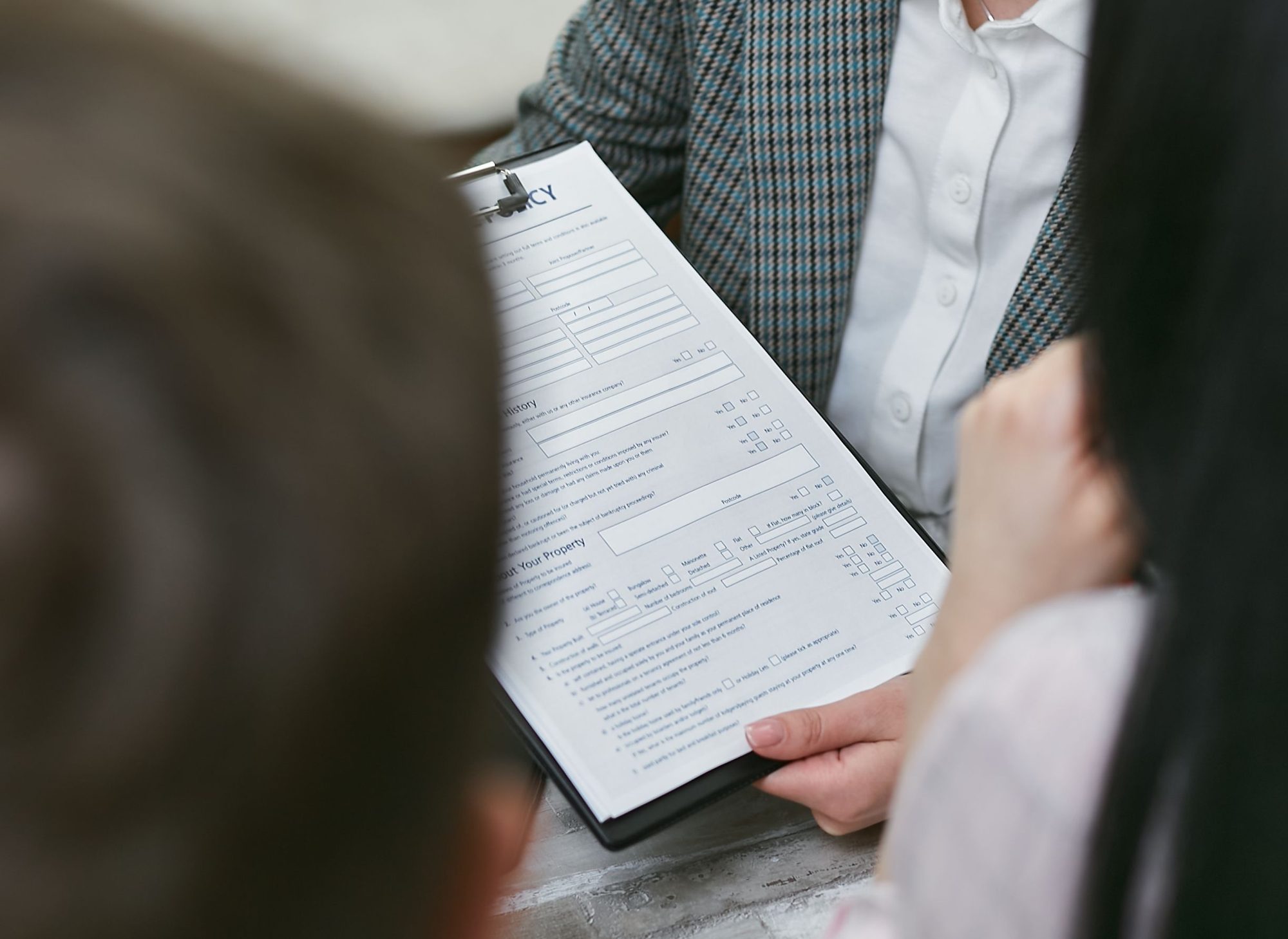 A close-up of a loan document being reviewed across a table