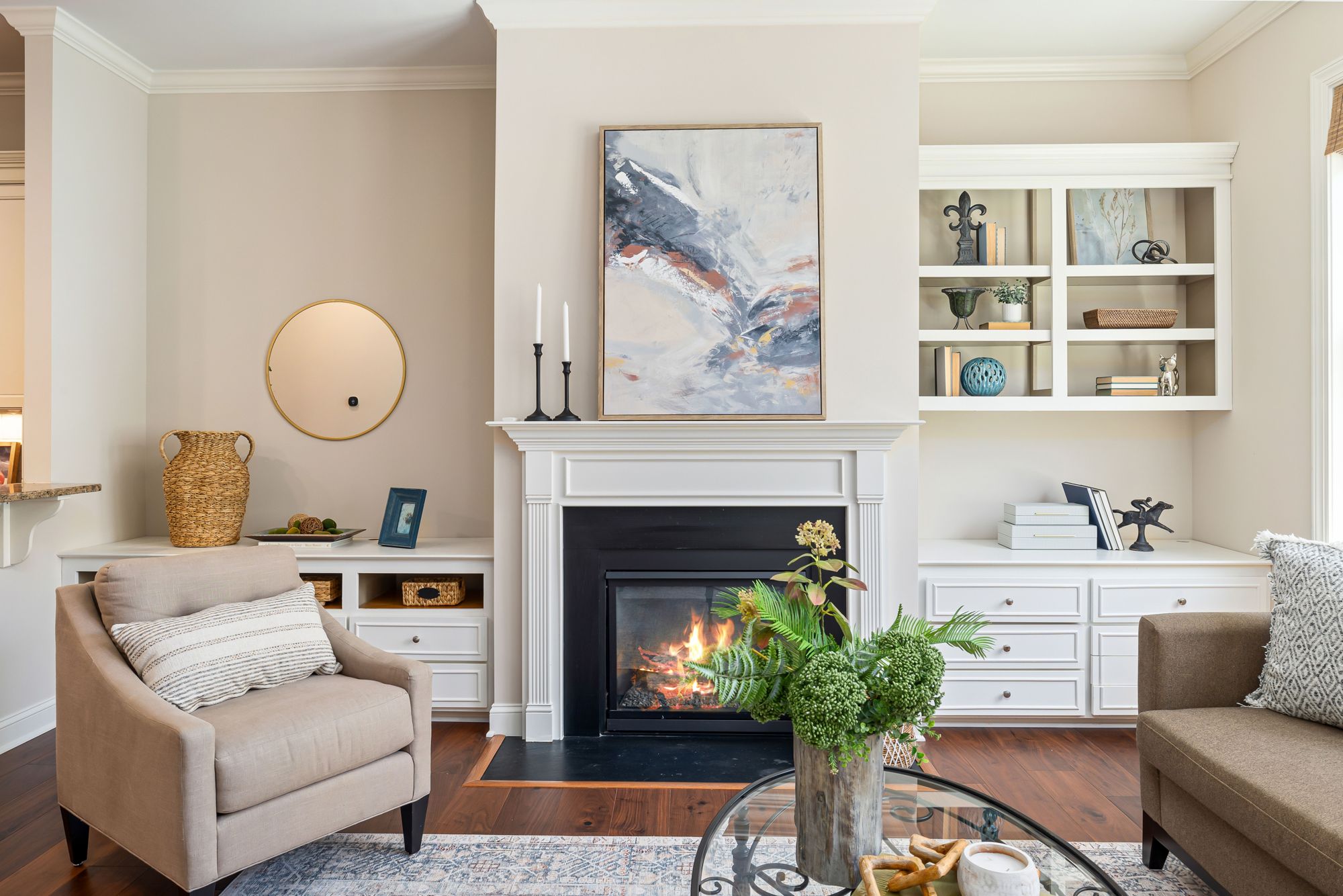 A bright living room with white built-in shelves around a fireplace