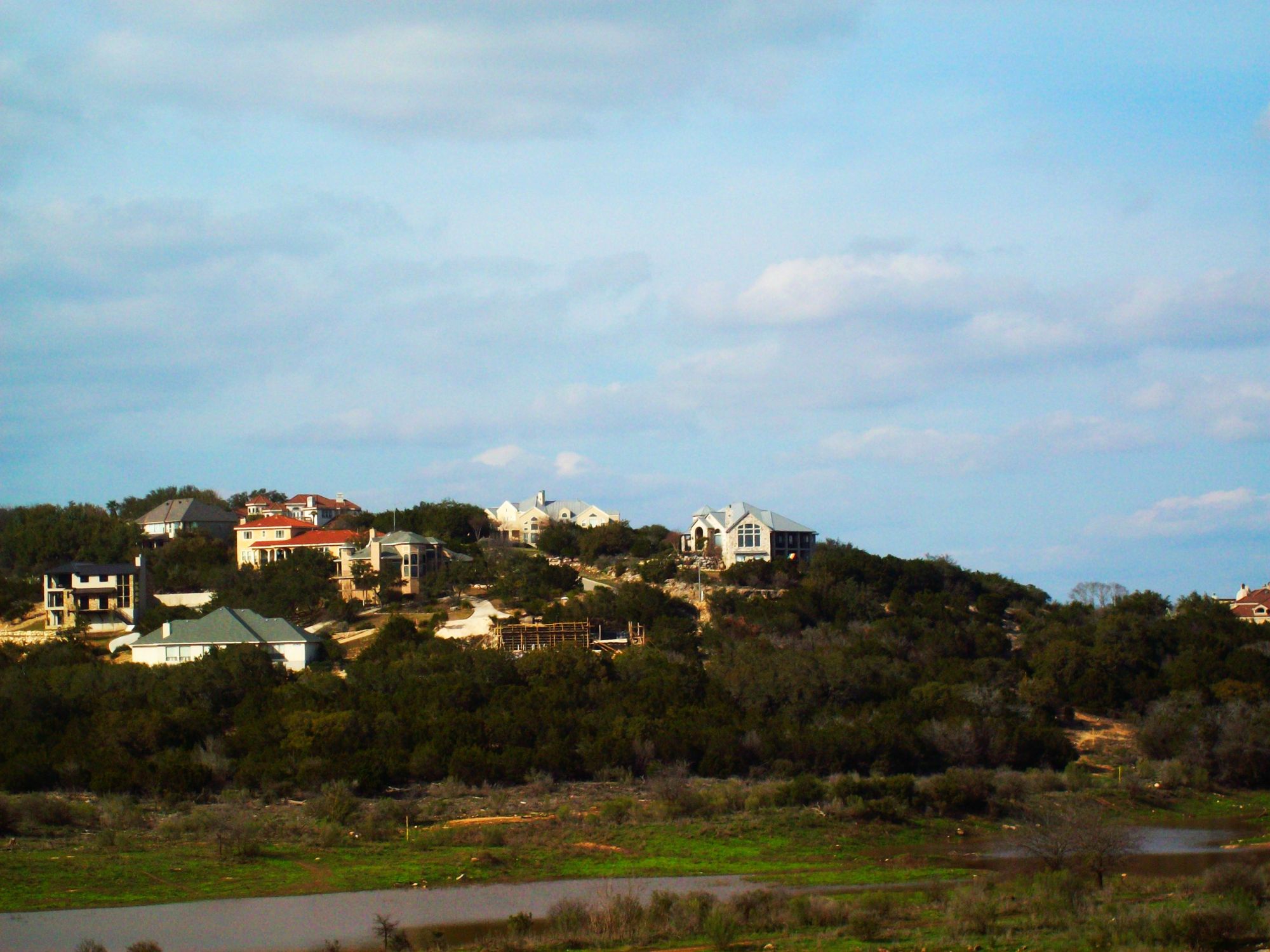 Homes along a wooded Hill Country ridge above a creek bed in Stone Oak